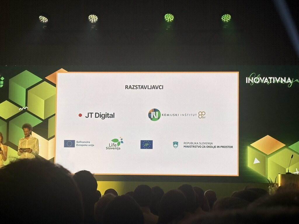 The stage screen at the national ceremony, listing JT Digital under Razstavljavci, the day's exhibitors.